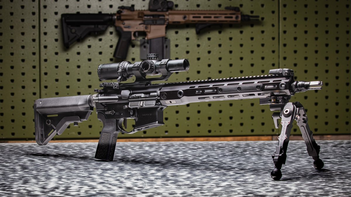 Watchtower Defense Raider15 rifle with an optic and bipod on a dealer display table