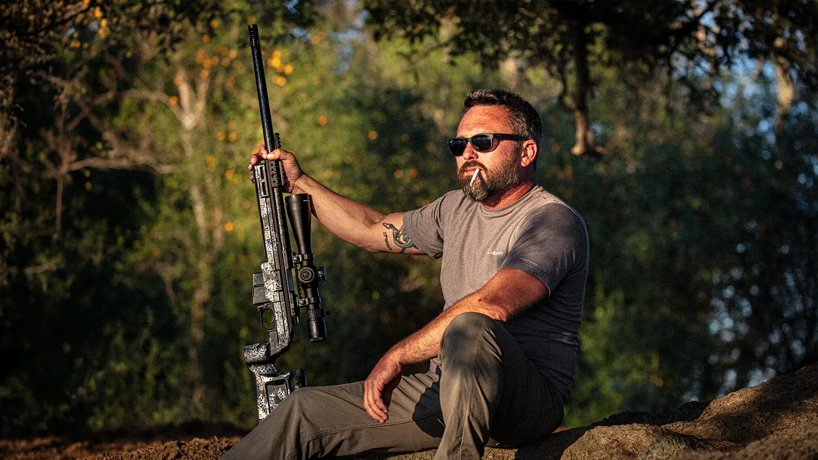 Shooter seated outdoors holding the Watchtower Defense Stratis Bravo bolt-action rifle in a KRG Bravo chassis